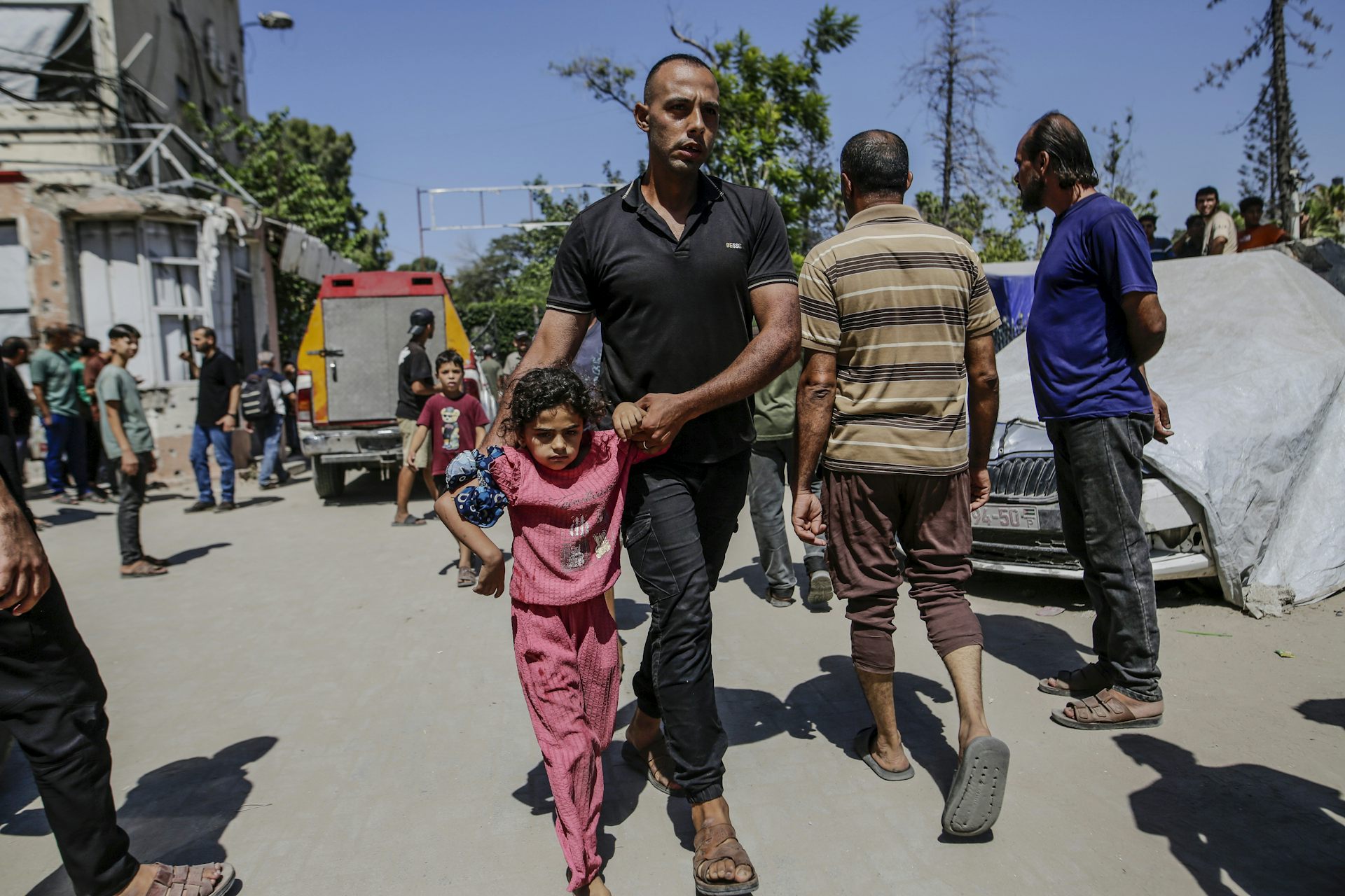 A Palestinian girl and man walk away from the site of an Israeli airstrike in Gaza City.