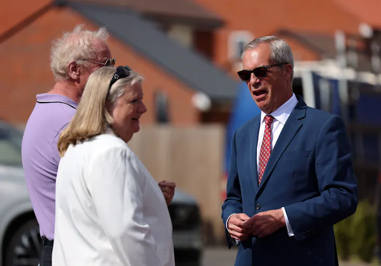 Nigel Farage speaks to a man and a woman in his Clacton constituency