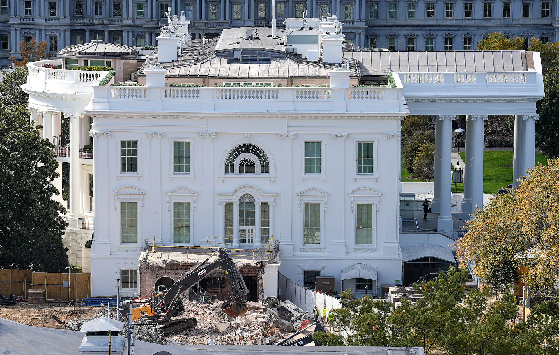 A big machine clears rubble next to the White House.