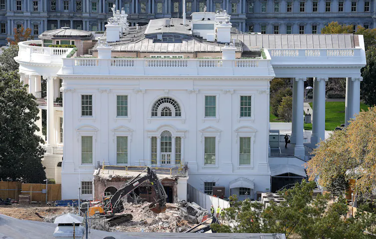 A big machine clears rubble next to the White House.