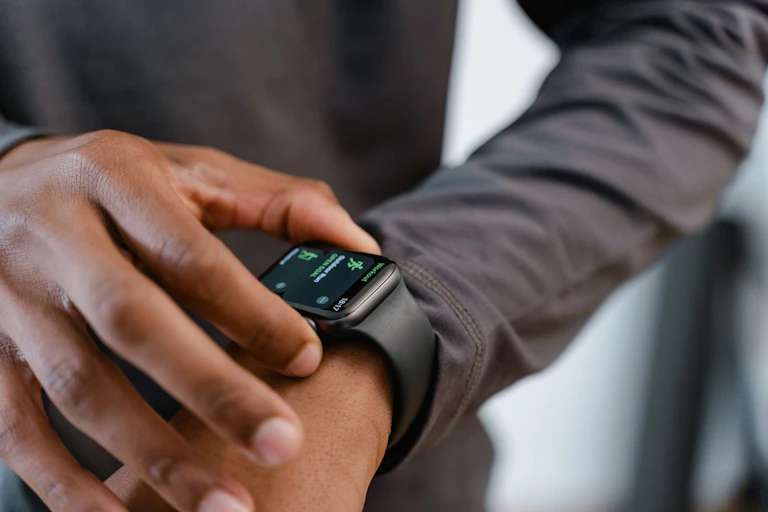 Man checking fitness tracker on wrist