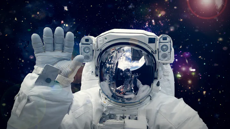 Close up crop of astronaut waving in space