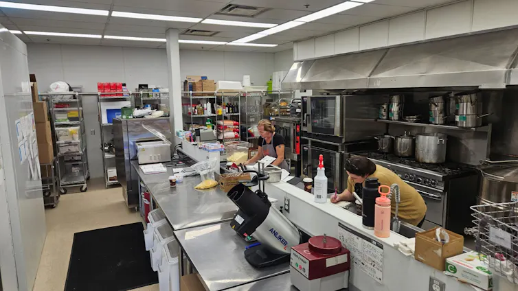 A kitchen with people preparing food.