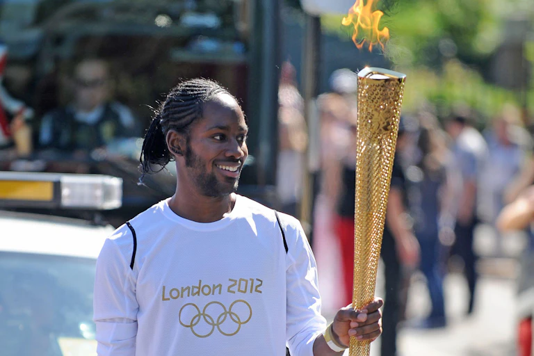 Jason Arday carrying the Olympic torch in London, 2021