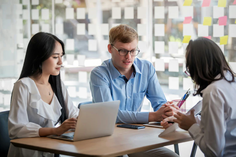 A group of people having a conversation in a workplace setting