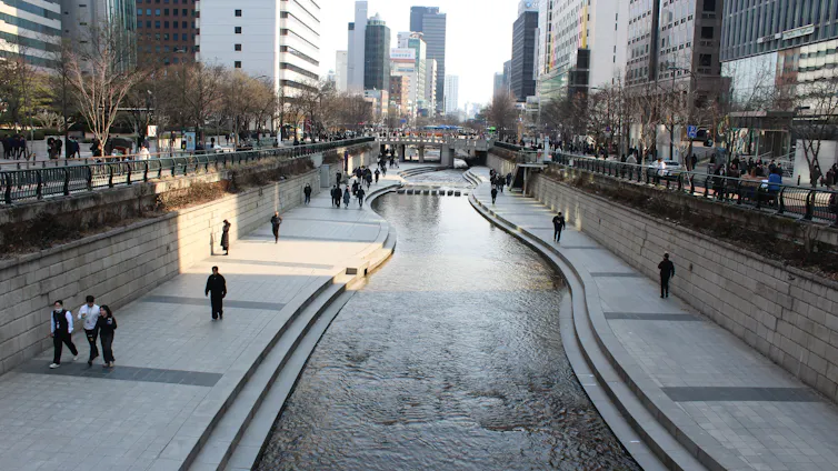 a river flows through a downtown area with tall buildings