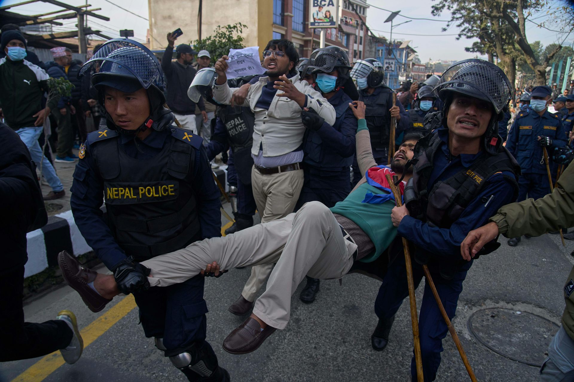 A young man is being carried away by police for protesting.