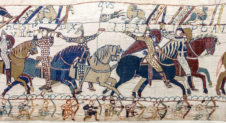 Escenas 55 y 56 del Tapiz de Bayeux en las que el duque Guillermo se levanta el yelmo para que lo reconozcan en el campo de batalla de Hastings. Eustaquio II, conde de Boulogne, lo señala con el dedo.