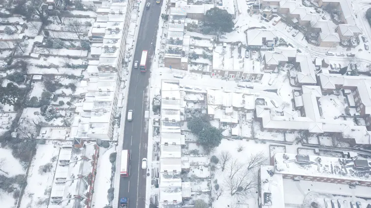 drone shot of london streets covered in snow