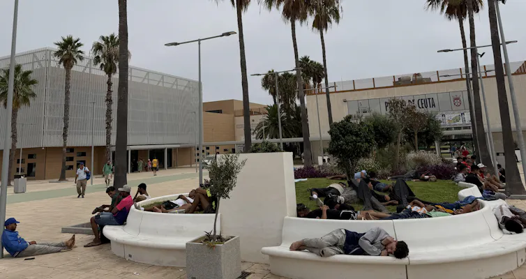 People resting on benches in a city park.