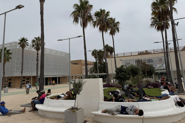 People resting on benches in a city park.
