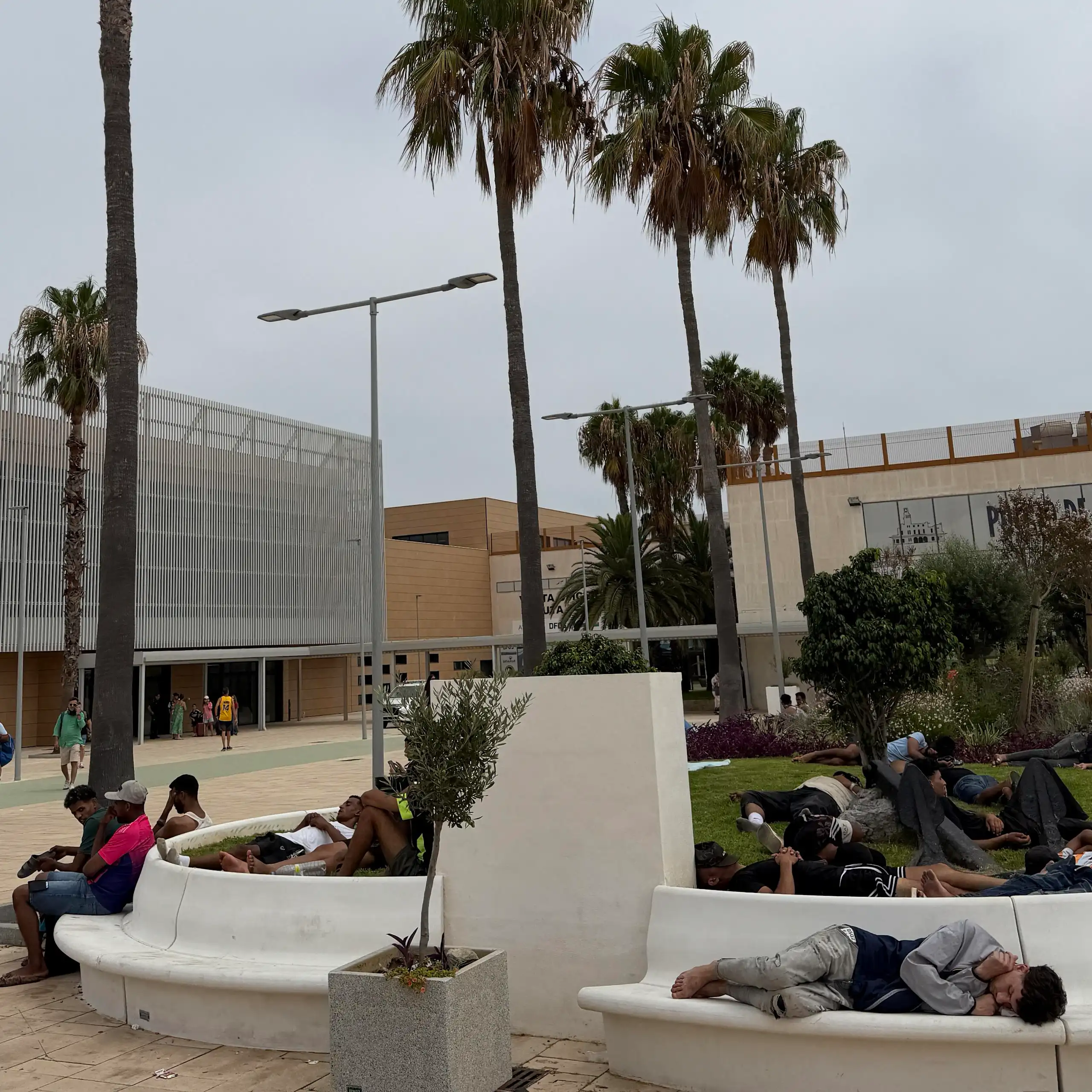 People resting on benches in a city park.