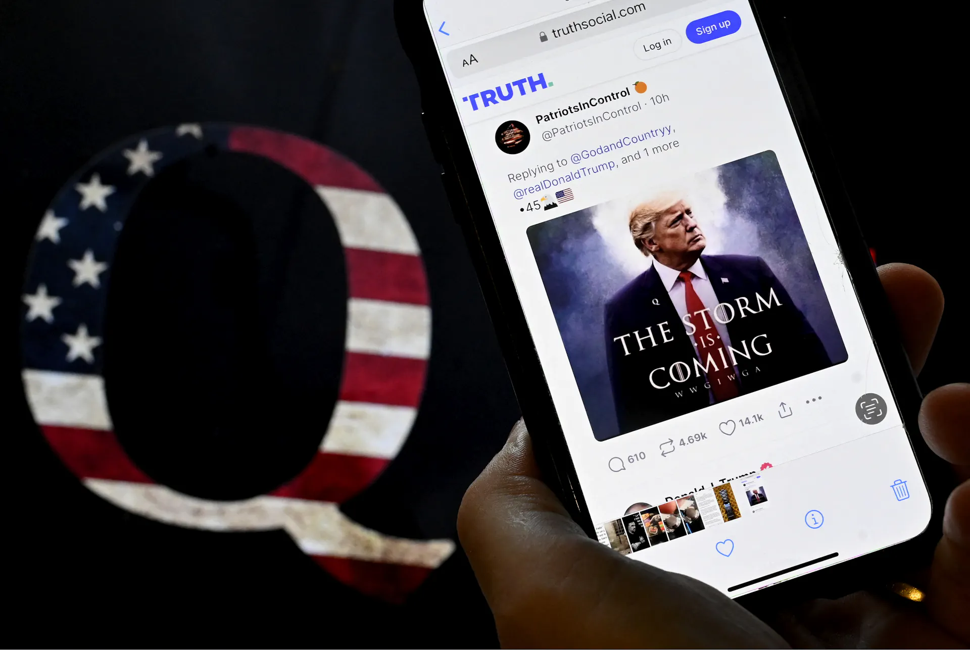 A letter Q is seen next to a social media account visible on a smartphone.