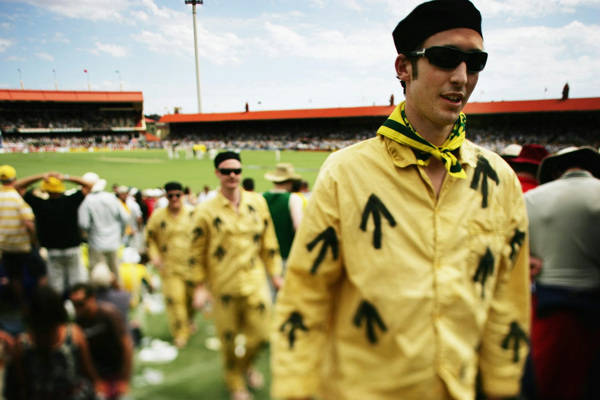 Men in yellow uniforms with black arrows.