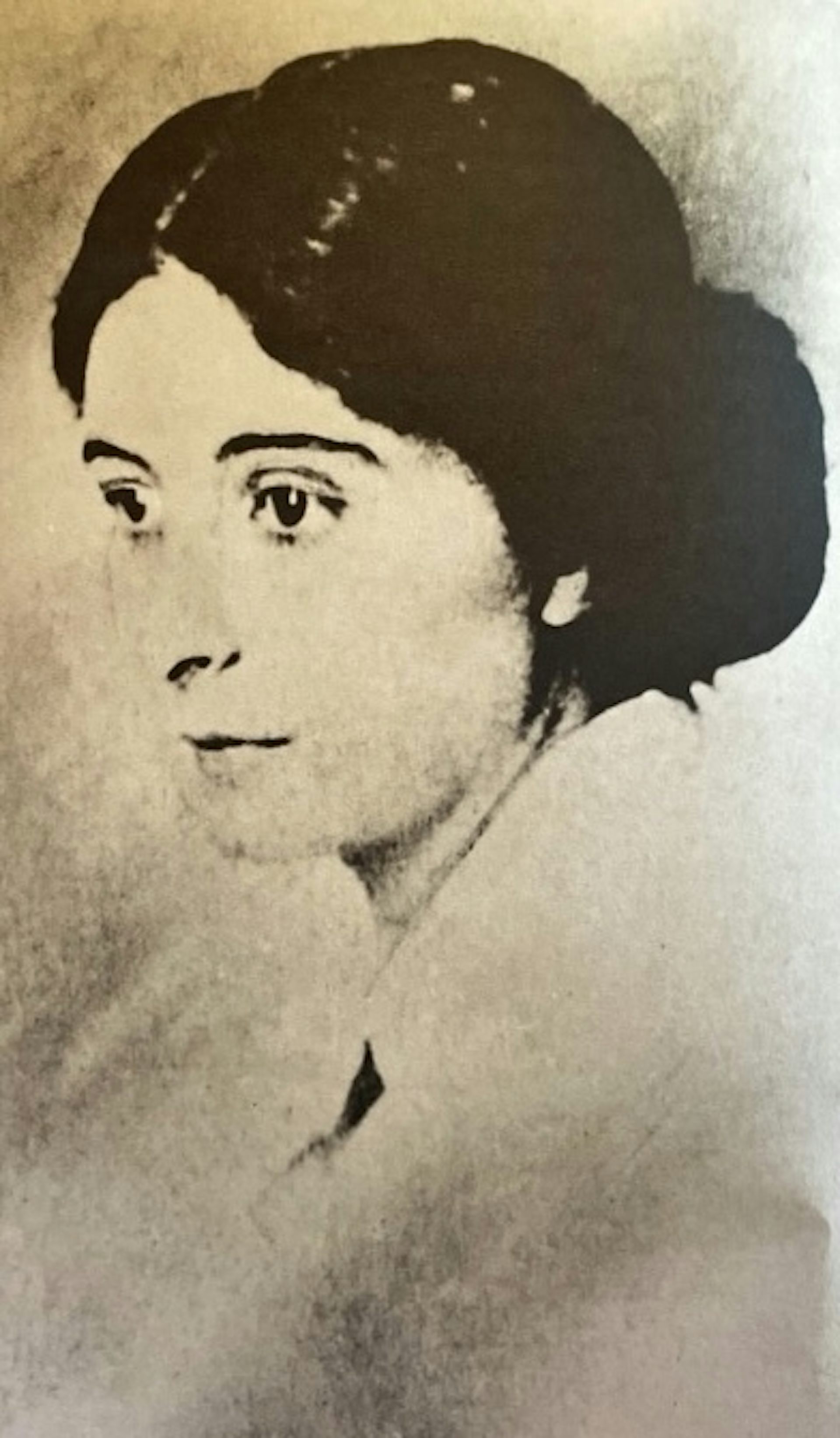 Portrait of a woman in half-profile, with her hair tied back.