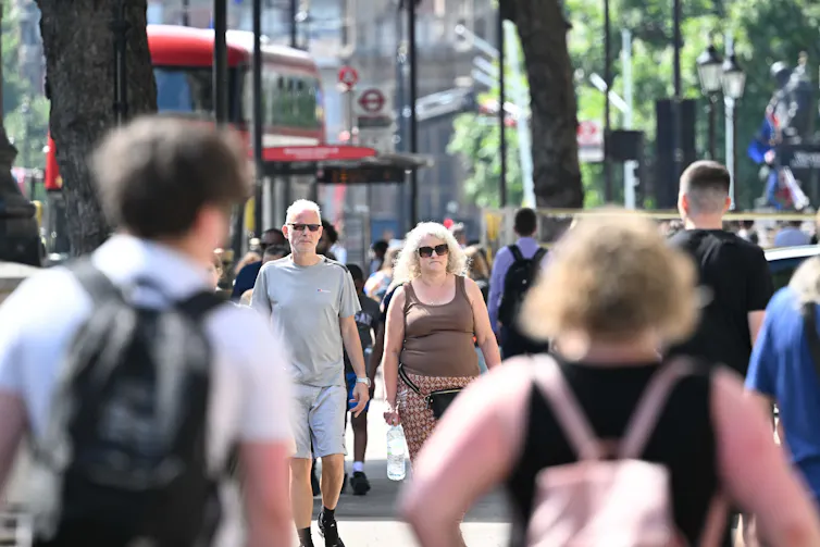 people in summer clothes crossing busy city road, v hot