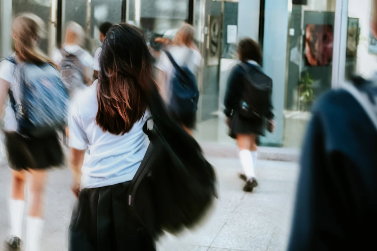 Slightly blurred image of children walking fast into school