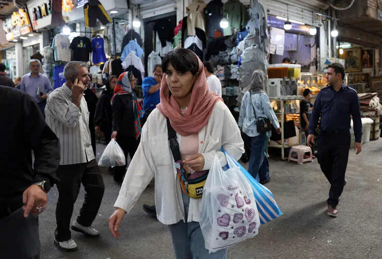 A woman walks through a bazaar in Tehran.
