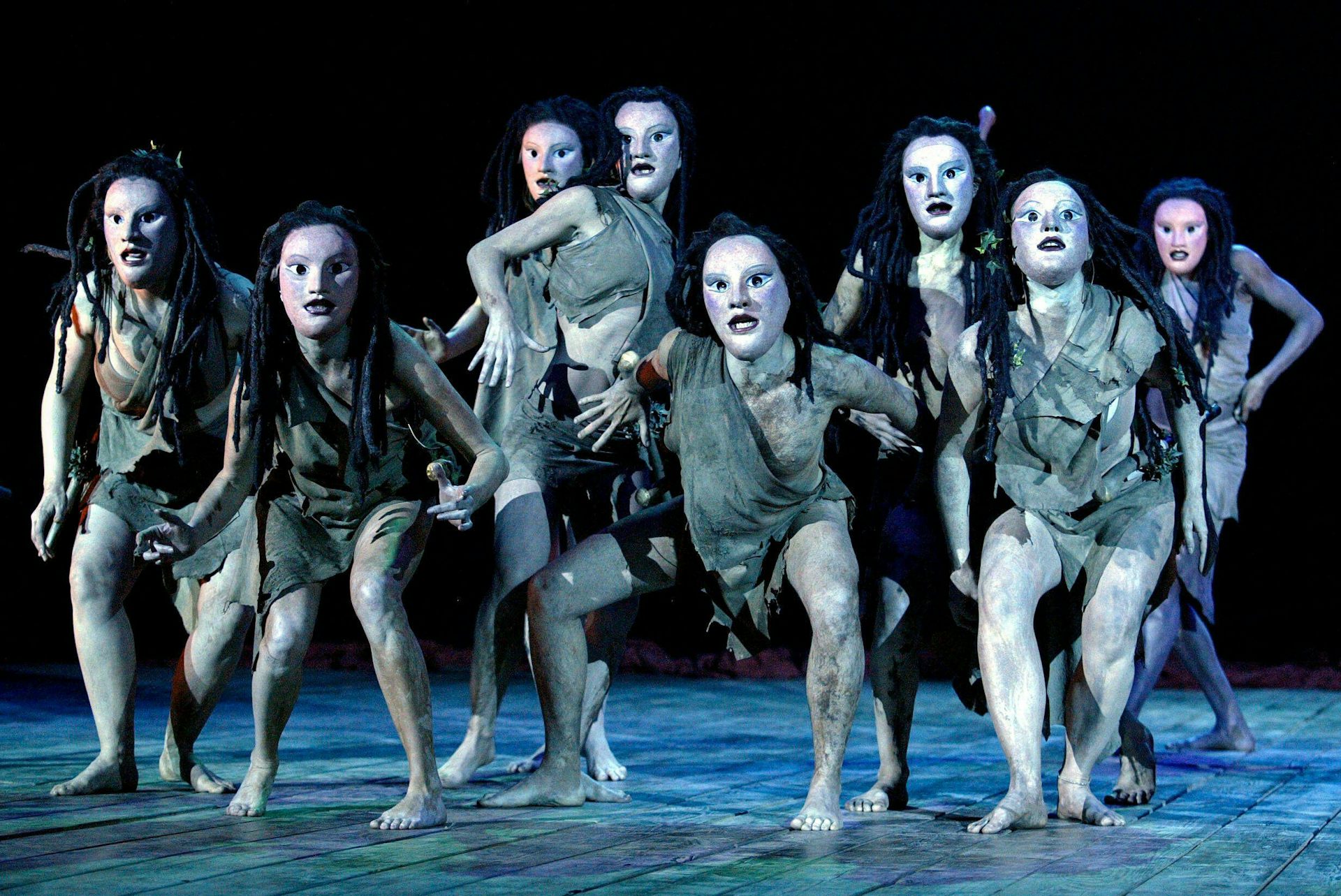 A chorus scene of actors wearing Greek masks.