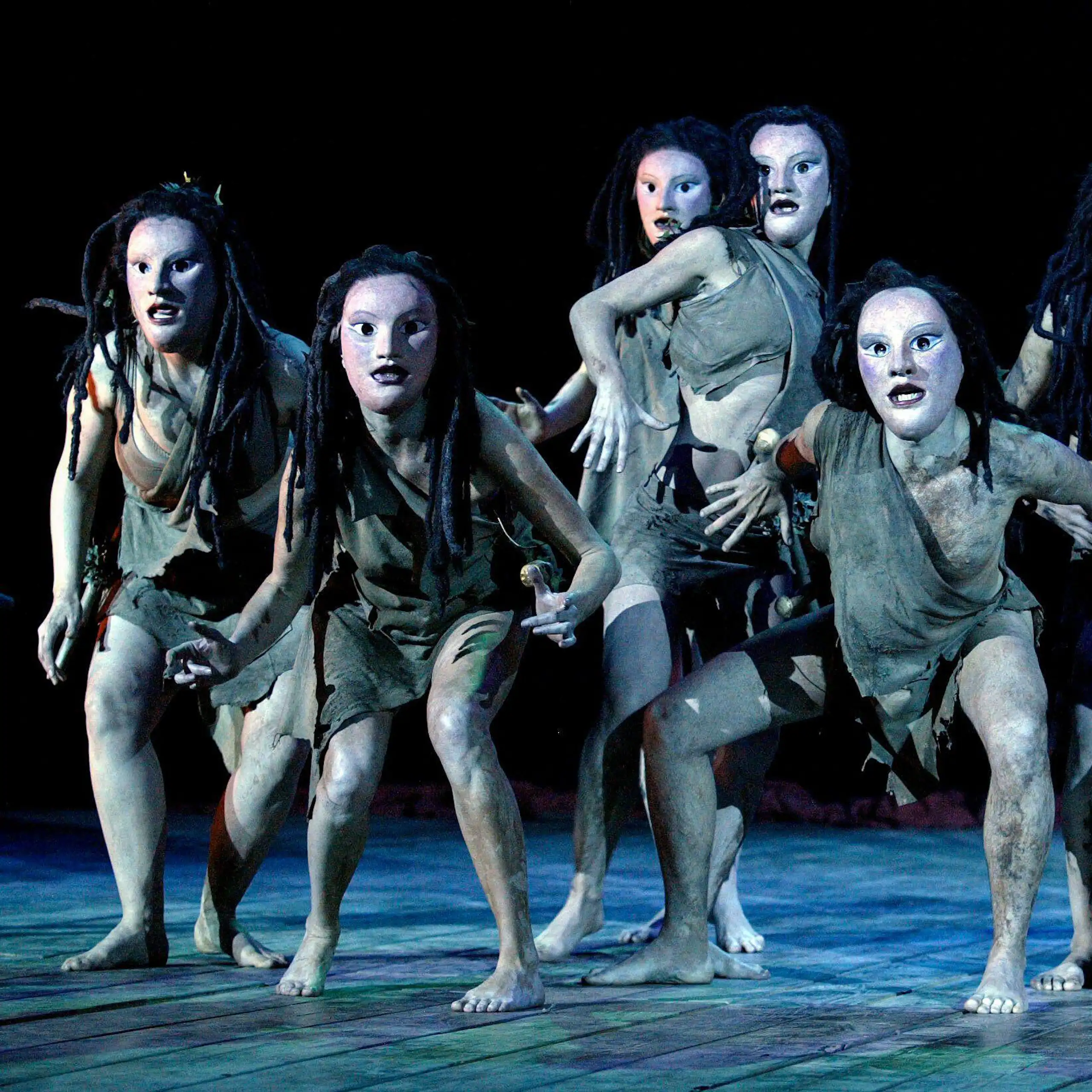 A chorus scene of actors wearing Greek masks.