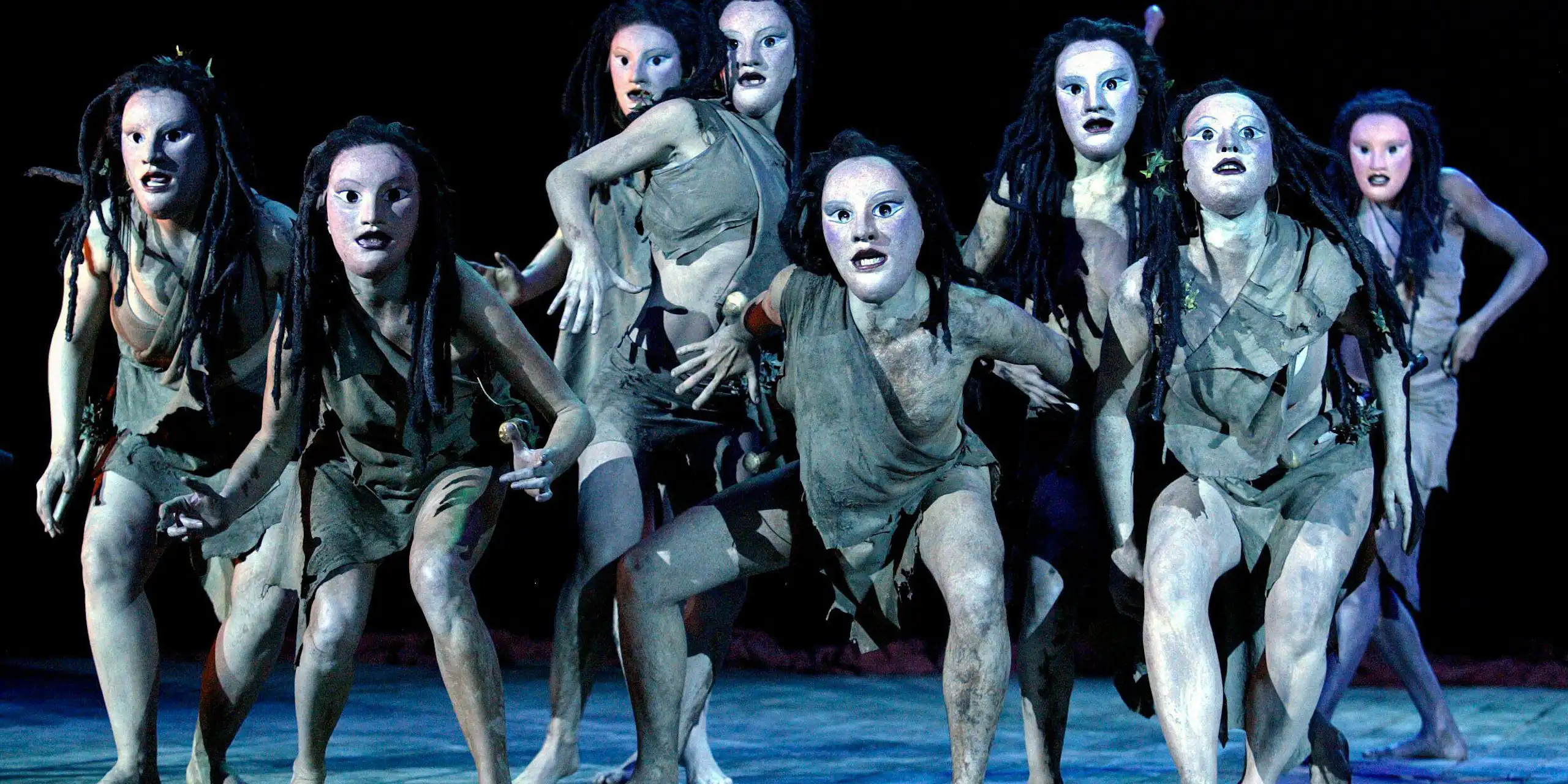 A chorus scene of actors wearing Greek masks.