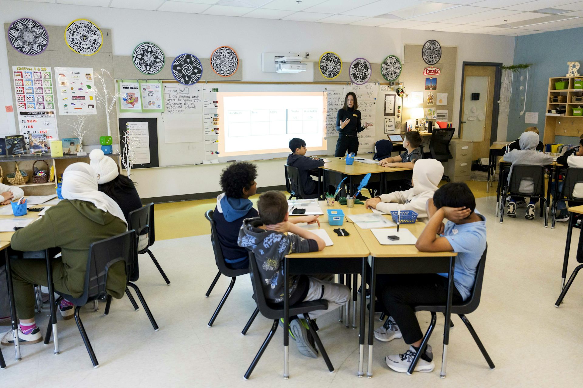 A teacher seen in front of a classroom of students.