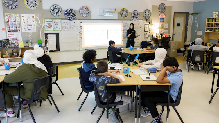 A teacher seen in front of a classroom of students.