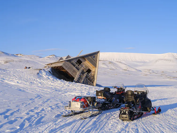 An A-frame home tipped on its side where the ground collapsed.