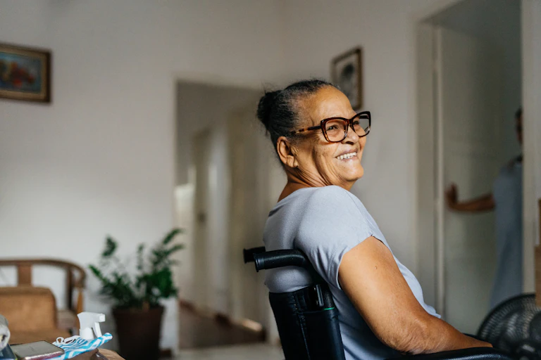 Older smiling woman at home in wheelchair.