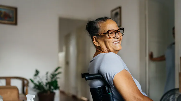Older smiling woman at home in wheelchair.