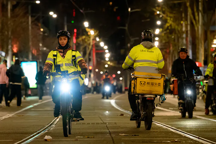 two delivery riders in high vis on e-bikes