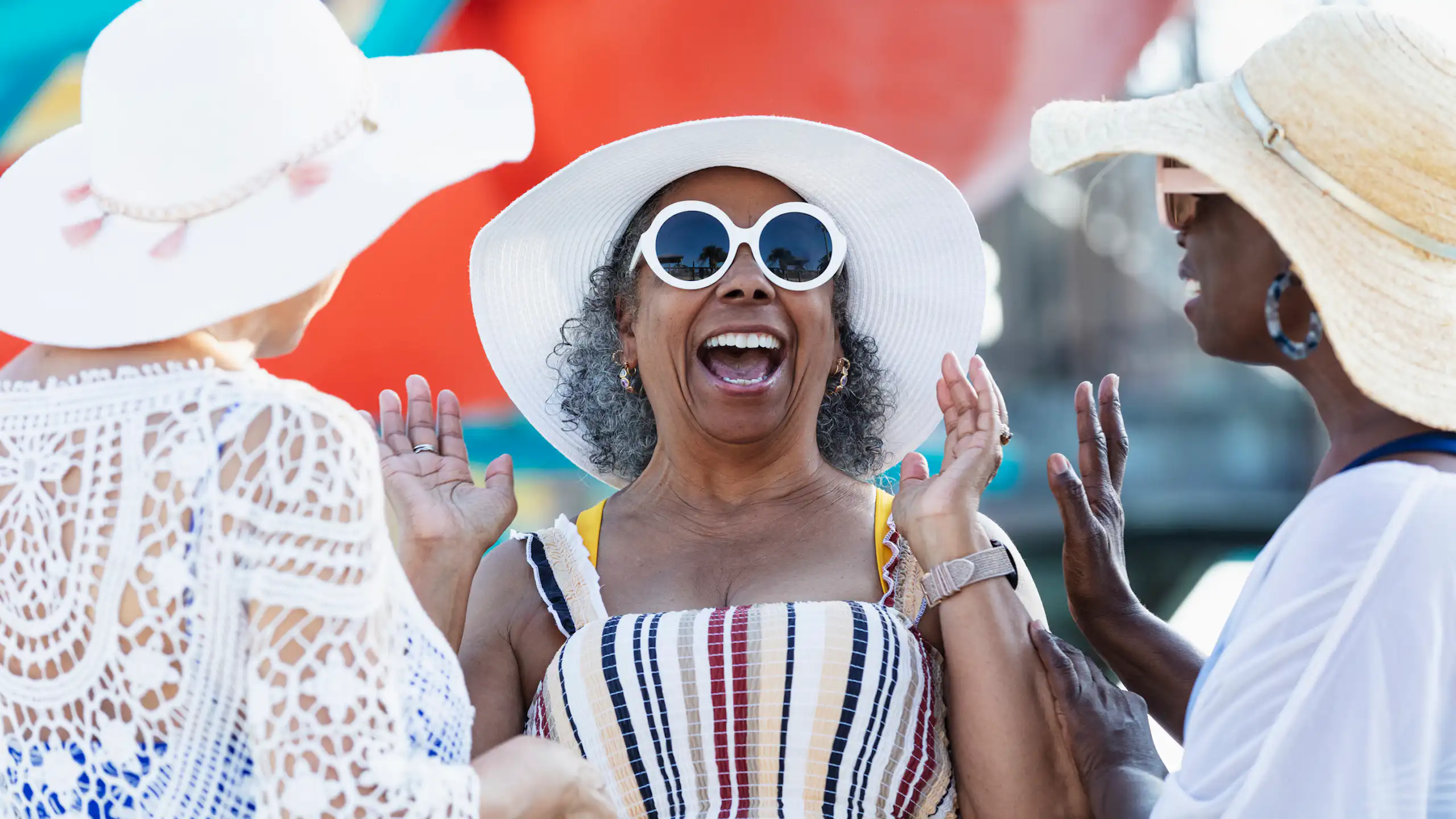 A group of women in floppy sun hats having a good time at a water park.