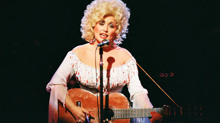 Dolly Parton actuando con una guitarra.