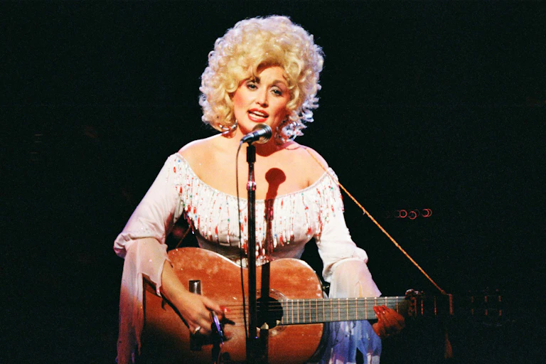 Dolly Parton actuando con una guitarra.