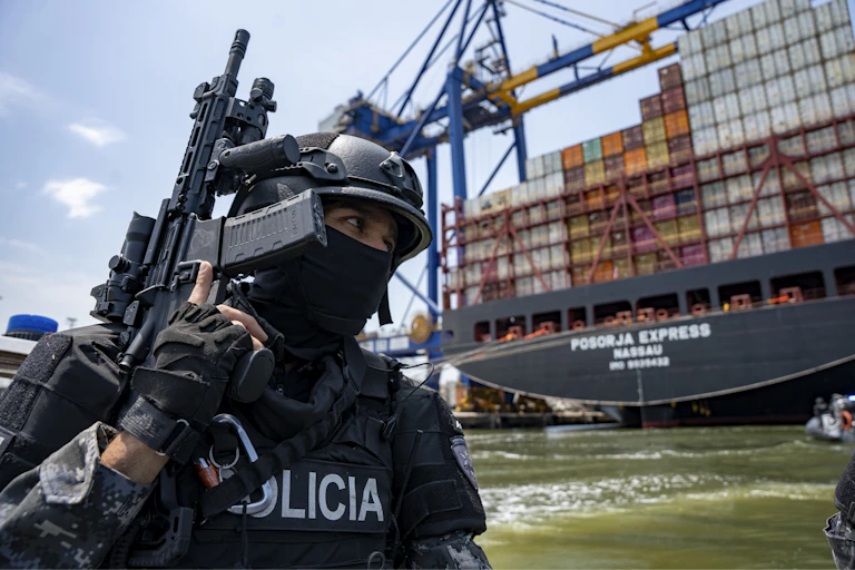 Ecuadorian security personnel pass a cargo ship on a patrol near the port of Guayaquil.