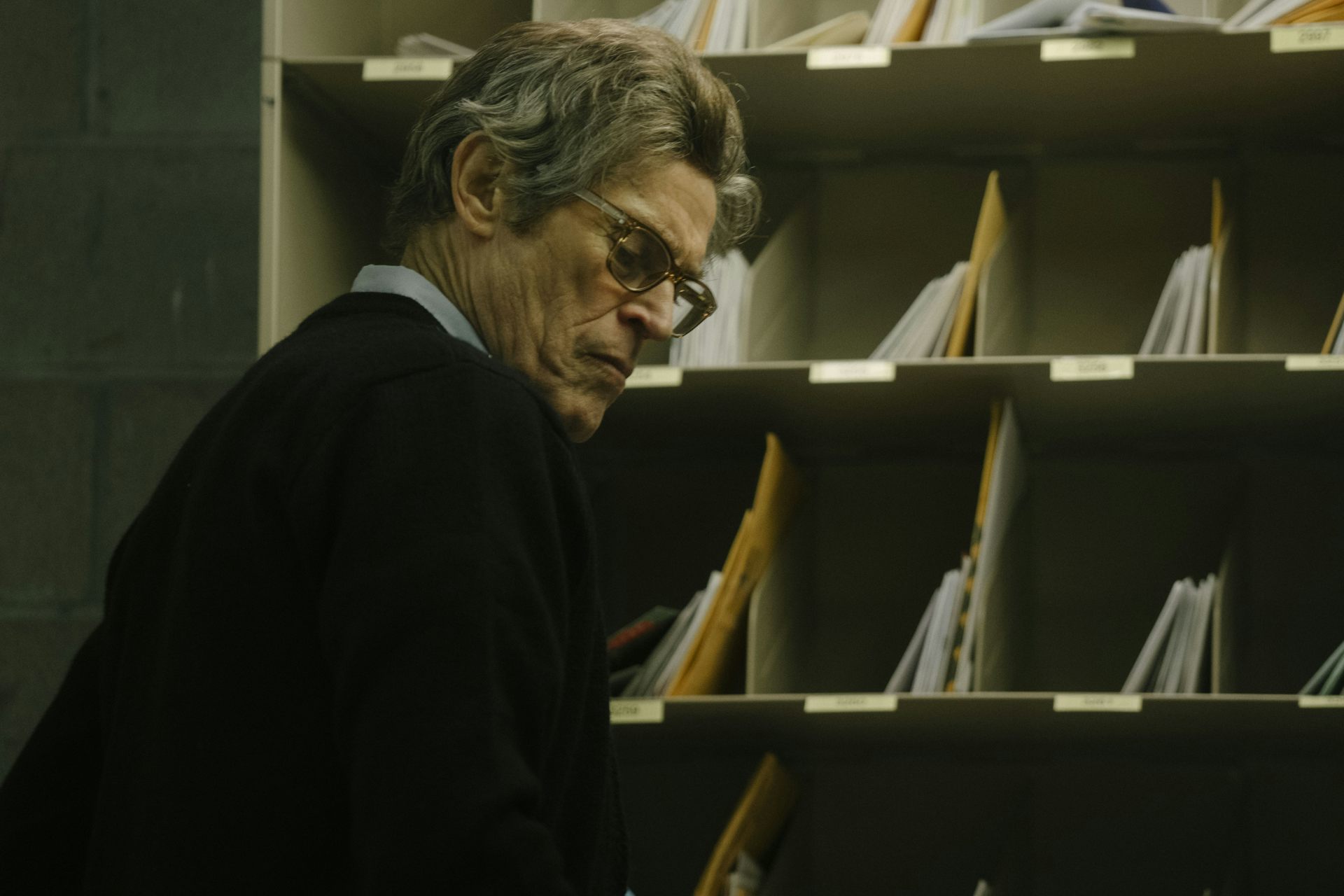 A man with specs in a postal sorting office.