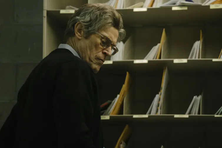 A man with specs in a postal sorting office.
