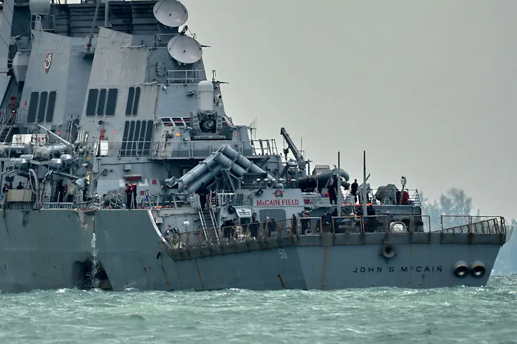 A warship is seen with a hole in its portside.