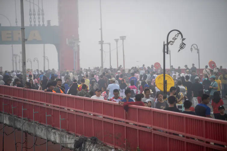 Warga berolahraga di Jembatan Ampera, Palembang, di tengah kabut asap akibat karhutla.