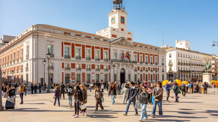Puerta del Sol square in Madrid with people walking across the square.