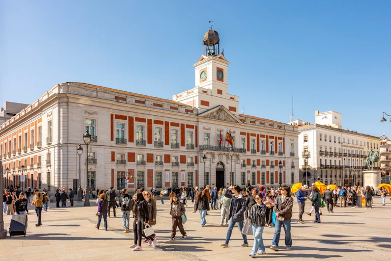 Puerta del Sol square in Madrid with people walking across the square.