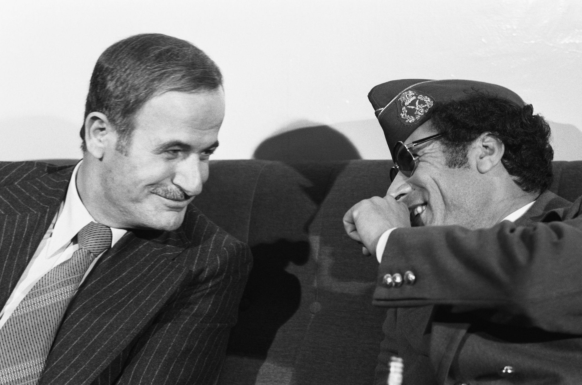 Two men chat while seated.