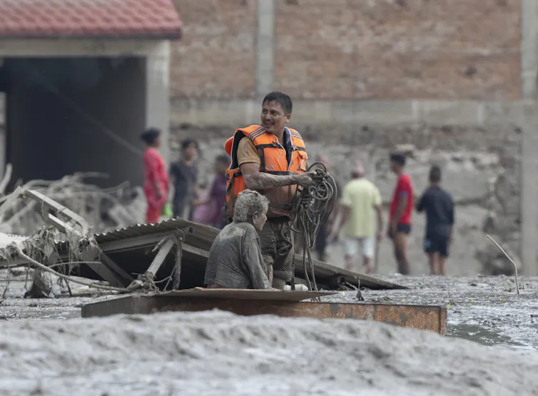Rescuers transport an elderly woman following a flash flood in Nepal's Nuwakot district.