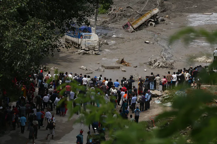People stare at a flood-damaged section of a highway in Nuwakot, central Nepal, following the flooding.