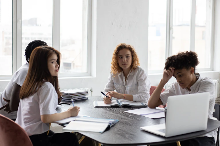 Students sitting at a table together studying.
