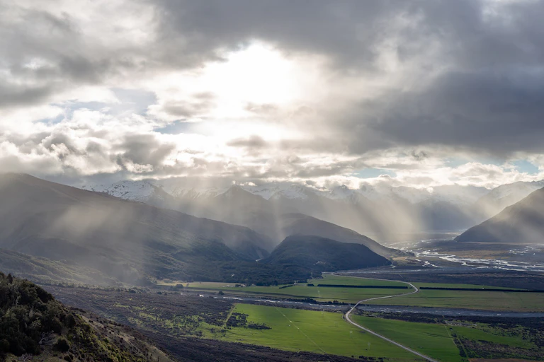 Sun shining through clouds over Waimakariri River basin in New Zealand
