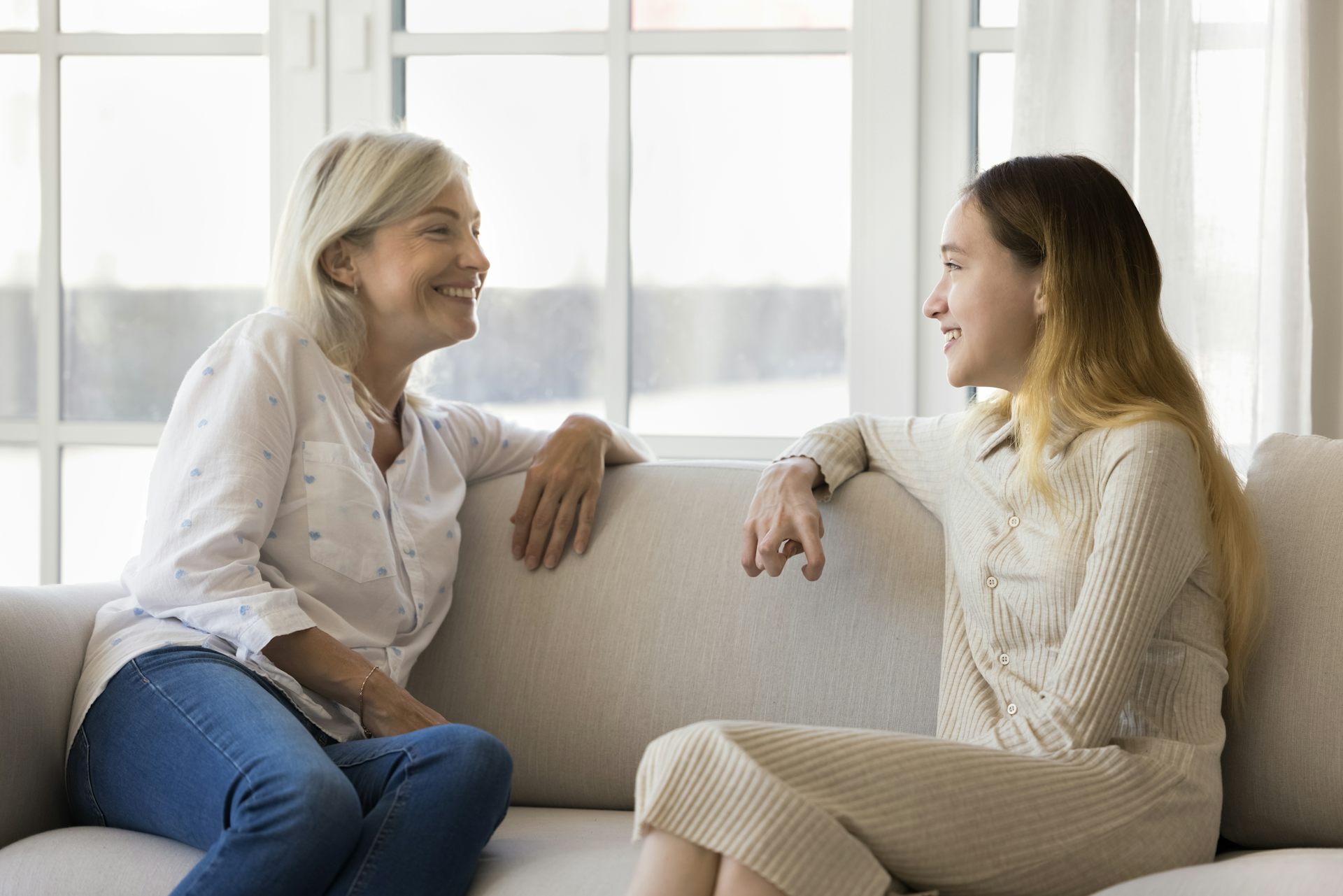 Woman and young woman talking on sofa