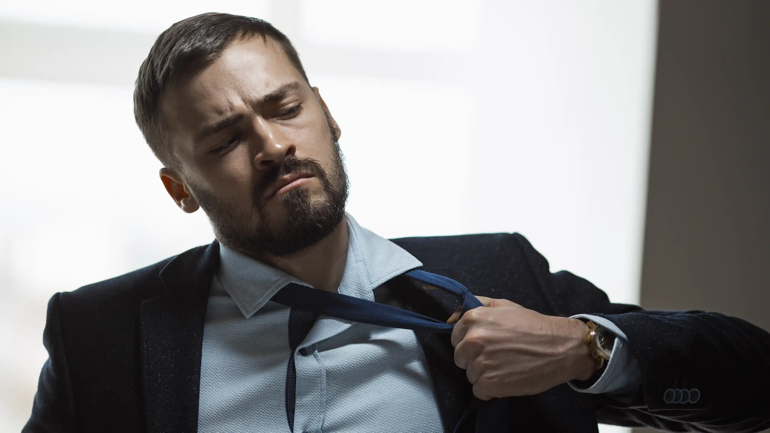 Un homme défaisant son nœud de cravate.