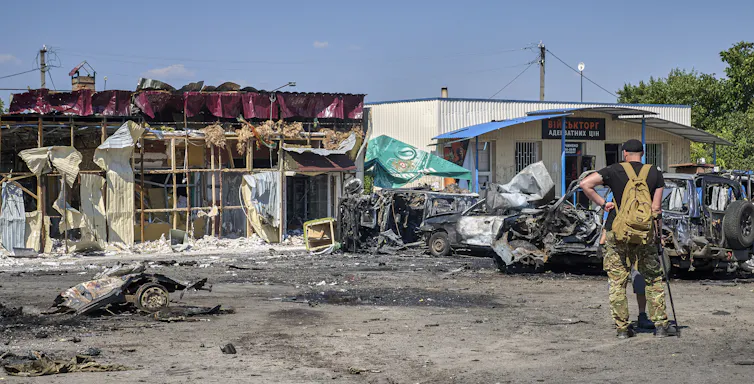 A man observing a building destroyed by a Russian missile strike.
