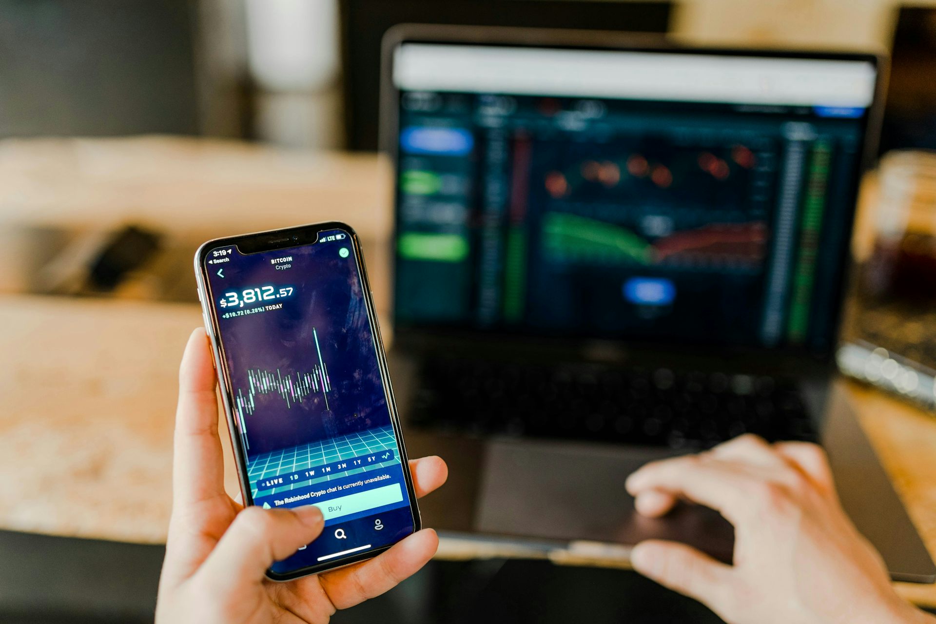 Une personne consulte ses placements sur son ordinateur portable et sur son téléphone